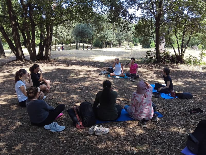 A circle of people practising under the oaks of a Roman park